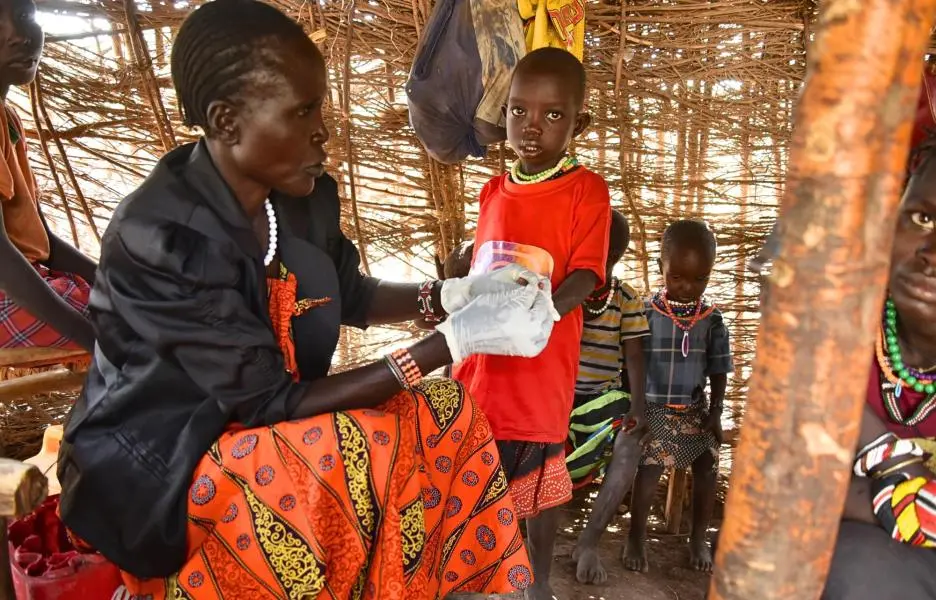 Elizabeth Lowiale, promotora de salud comunitaria, realiza pruebas de malaria a Kang'usu Domong'iro, de 3 años, en su casa mientras su madre, Cheparkeno Domong'iro, observa. Kenia
