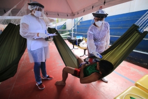 Health team takes the temperature of an indigenous Warao man in an isolation and observation center for people with mild cases of COVID-19