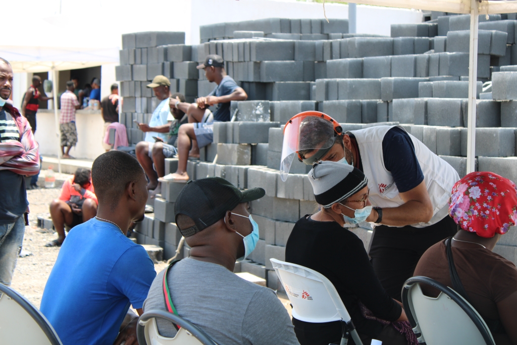 Un integrante de MSF atendiendo a un grupo de pesonas migrantes