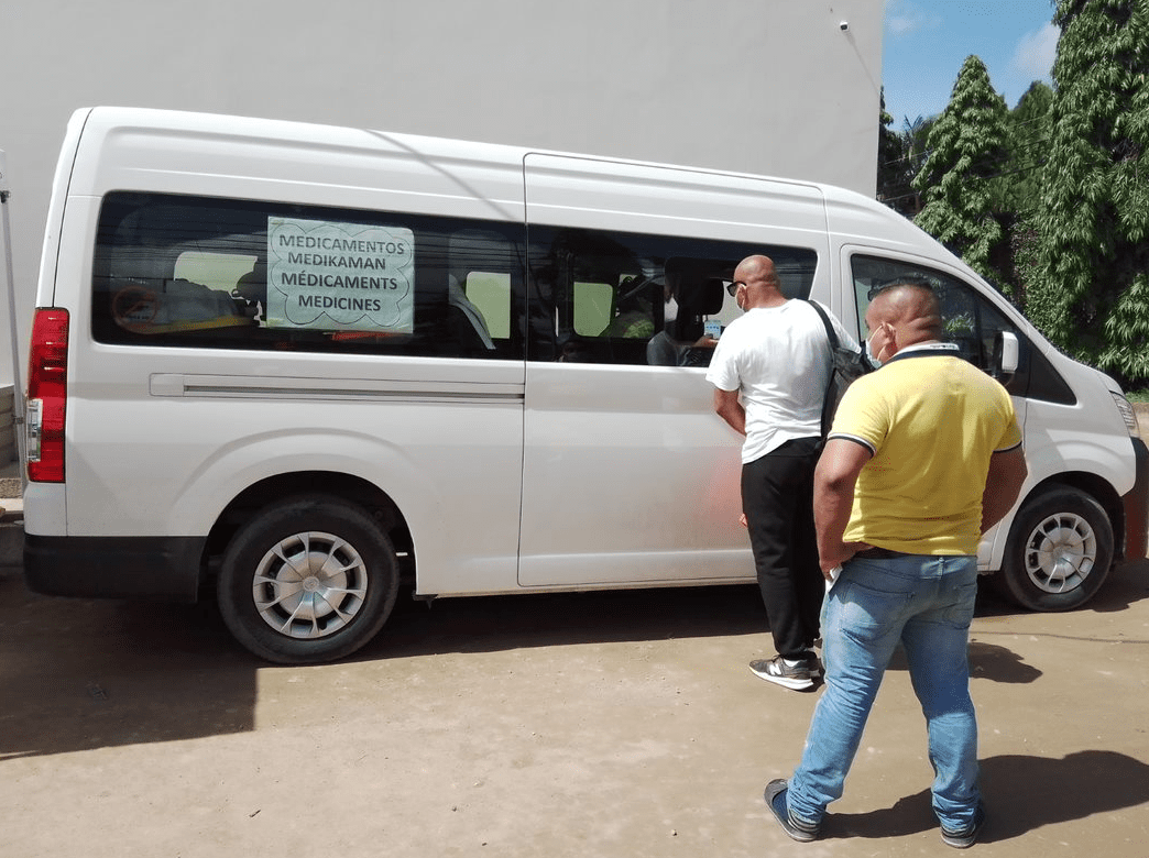 Dos pacientes de MSF reciben en la farmacia de la clínica móvil los medicamentos que les han indicado previamente en la consulta médica. 