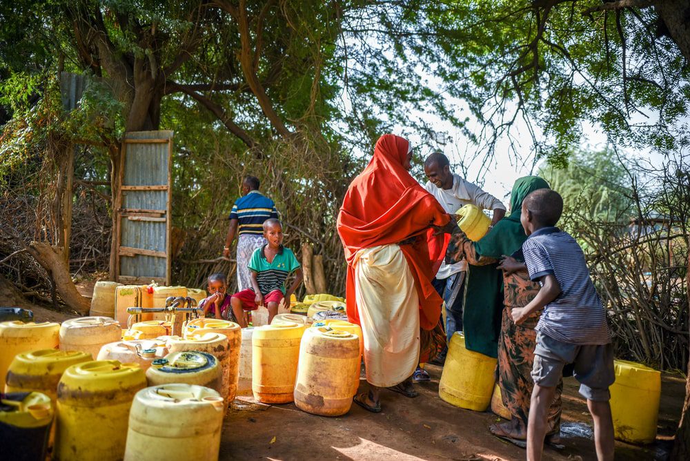 Personas refugiadas recogen agua en un punto de agua del campo de Dagahaley en Dadaab. 