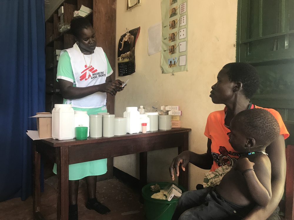 La enfermera de MSF Abau Susan entrega la medicación a una madre y le explica cómo y cuándo debe dársela a su hijo en el Centro de Atención Primaria del Ministerio de Salud en Kediba, Sudán del Sur.