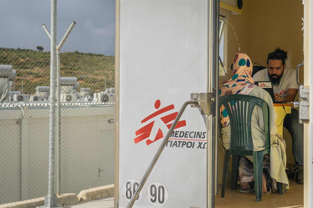 Un promotor de salud de MSF hablando con un paciente dentro de la clínica móvil en el Centro de Acceso de Control Cerrado en Zervou, Samos. Grecia