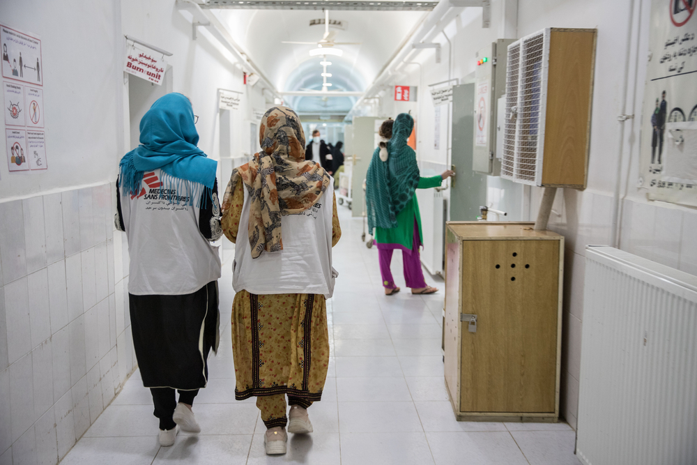 Dos trabajadoras de MSF caminan por el pasillo en el departamento de pacientes hospitalizados femeninos en el hospital Boost apoyado por MSF.