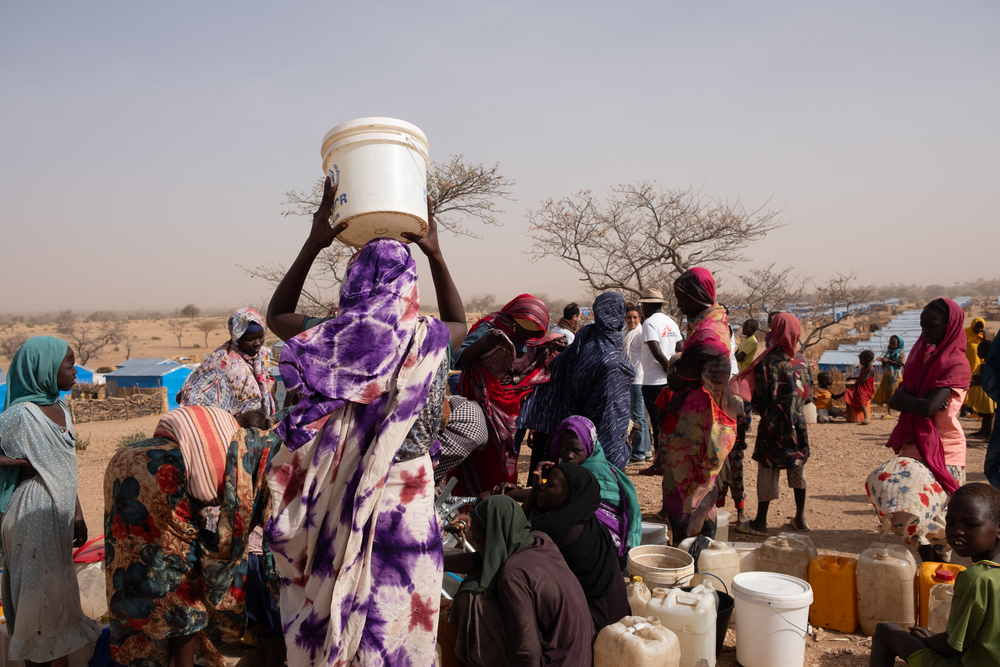 Personas recoge agua en el punto de distribución de MSF en el campo de Metche