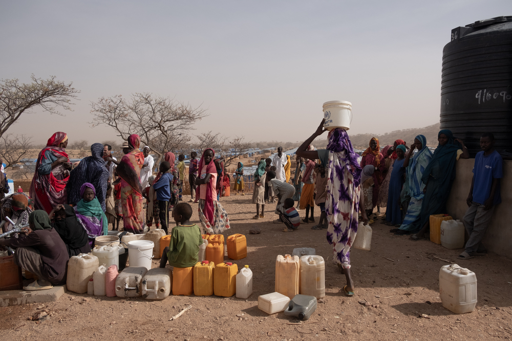Personas recogiendo agua en el punto de distribución de MSF en el campo de Metche