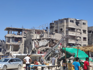 Un grupo de personas frente a un edificio bombardeado en Rafah, Gaza.