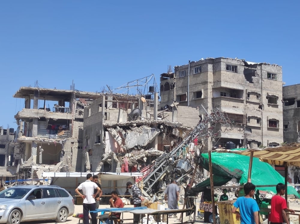 Un grupo de personas frente a un edificio bombardeado en Rafah, Gaza.