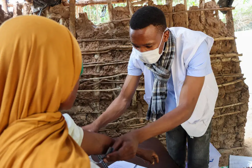 Un enfermero de MSF usa una mascarilla reutilizable en lugar de una mascarilla desechable, durante una consulta en Mozambique. Estas mascarillas ayudan a combatir la crisis climática. 