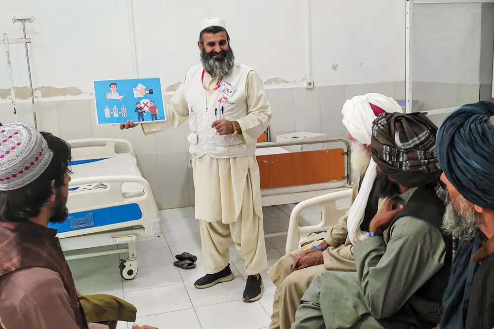 Haji Abdul Rehman Niamatullah, promotor de salud de MSF explica a un grupo de pacientes cómo prevenir infecciones y la importancia de tomar correctamente los antibióticos que les receta el médico.