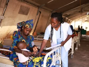 Personal de MSF toma los signos vitales de Nura, la hija de Zainab, en el centro de alimentación terapéutica para pacientes hospitalizados con desnutrición aguda, Nigeria.