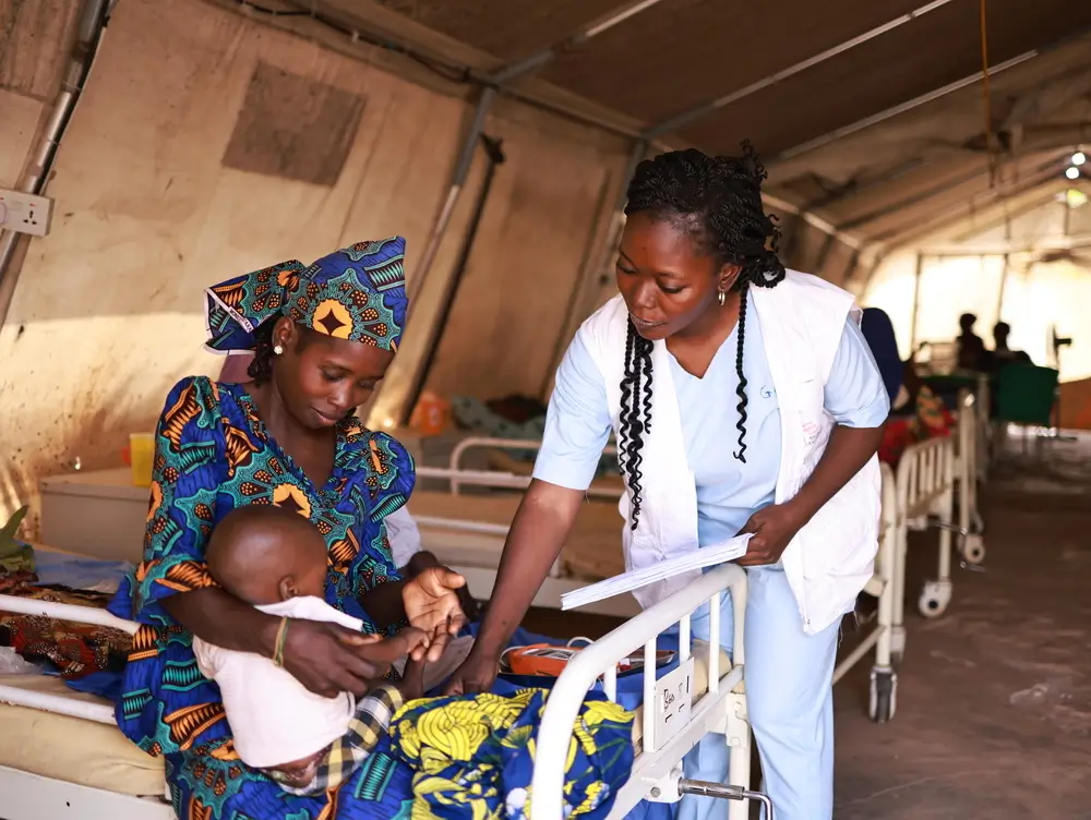 Personal de MSF toma los signos vitales de Nura, la hija de Zainab, en el centro de alimentación terapéutica para pacientes hospitalizados con desnutrición aguda, Nigeria.