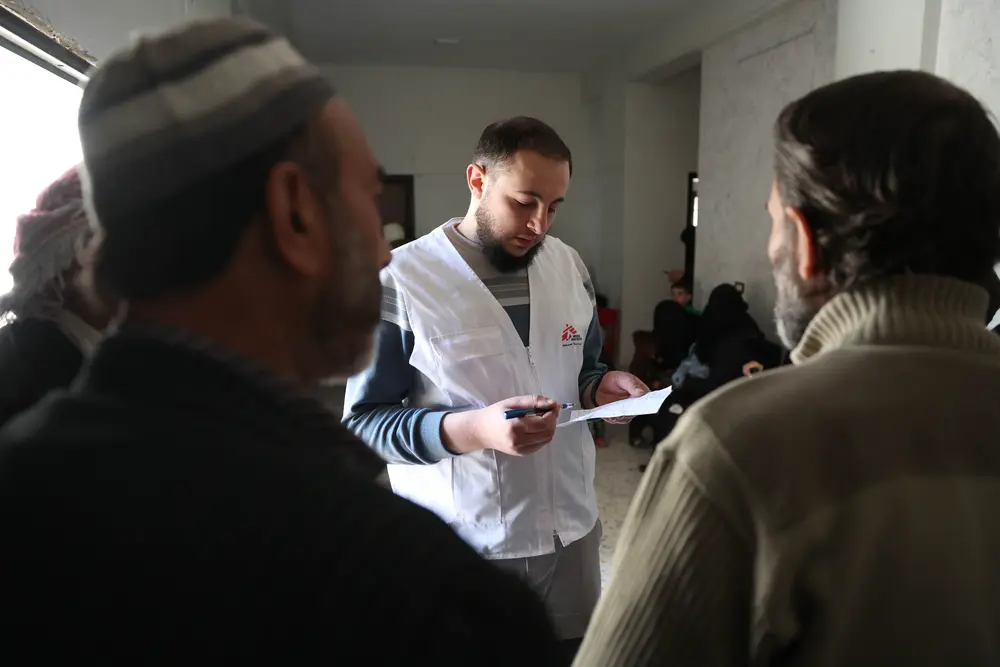 Abdullatif Bokay, responsable de promoción de la salud de MSF, proporciona a los pacientes en la sala de espera de la clínica móvil en Guta Oriental (Siria) información esencial sobre enfermedades no transmisibles (ENT). 