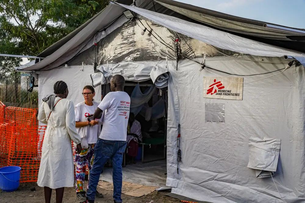Personal de MSF habla con el cuidador de un paciente para explicarle la condición del paciente.