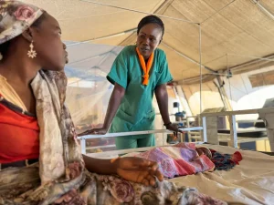 Solange revisa a Dar-ul Salam, la madre de un bebé recién nacido, durante una consulta en la unidad de maternidad de MSF en la clínica del campoo de Aboutenege. Chad, 2025.