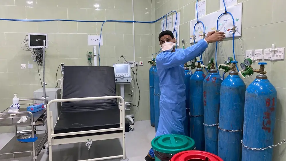 Un miembro del personal de enfermería ajusta los niveles de oxígeno a un paciente grave con COVID-19 en la unidad de cuidados intensivos del hospital Al-Gomhuria. Adén, Yemen, agosto de 2020.