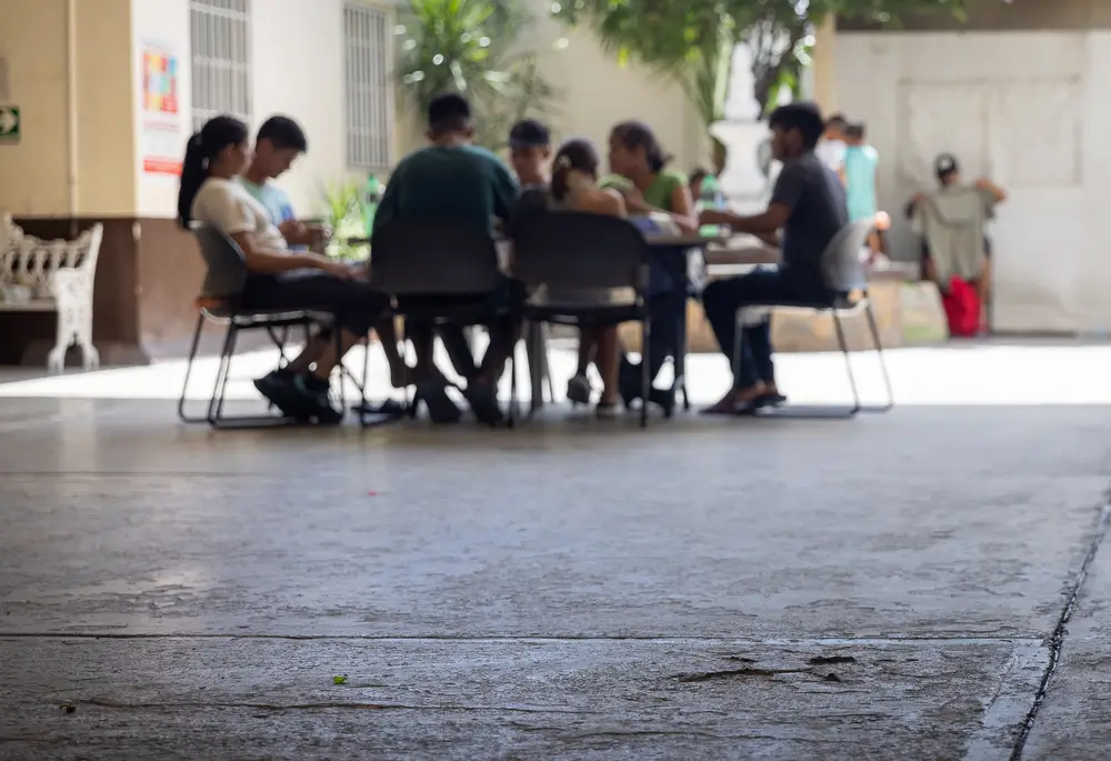 Un grupo de jóvenes migrantes juega a las cartas en la Casa del Migrante en Reynosa, Tamaulipas. México 2025. 