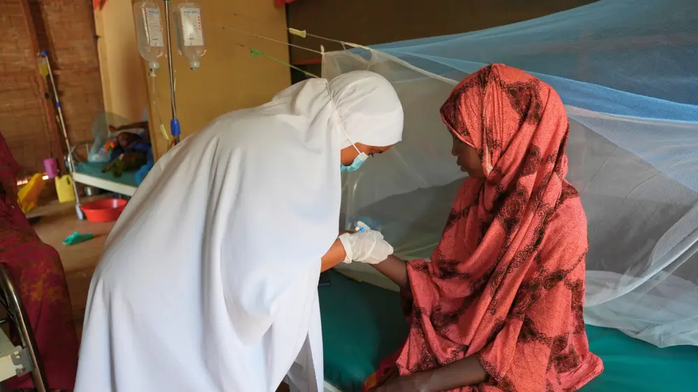 Lul Mohammed Dahir, enfermero apoyado por MSF, atiende a una paciente de Kala-azar en la sala de mujeres adultas del ala de aislamiento de Kala-azar del Hospital de Referencia del Condado de Wajir.