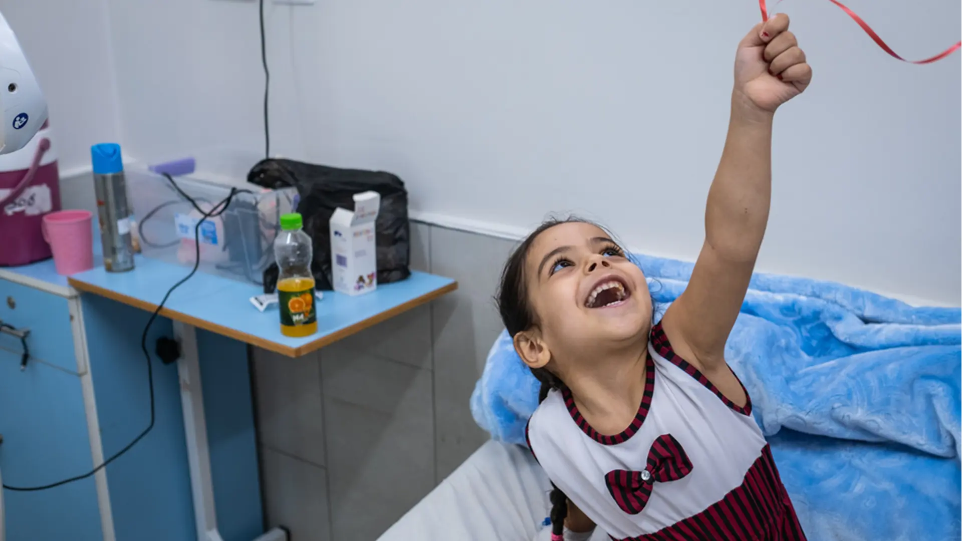 Hala, de cuatro años, juega con un globo justo un día después de que los cirujanos de la unidad de reconstrucción de extremidades de MSF en el hospital Al-Awda, en Gaza, la operaran en el pie.