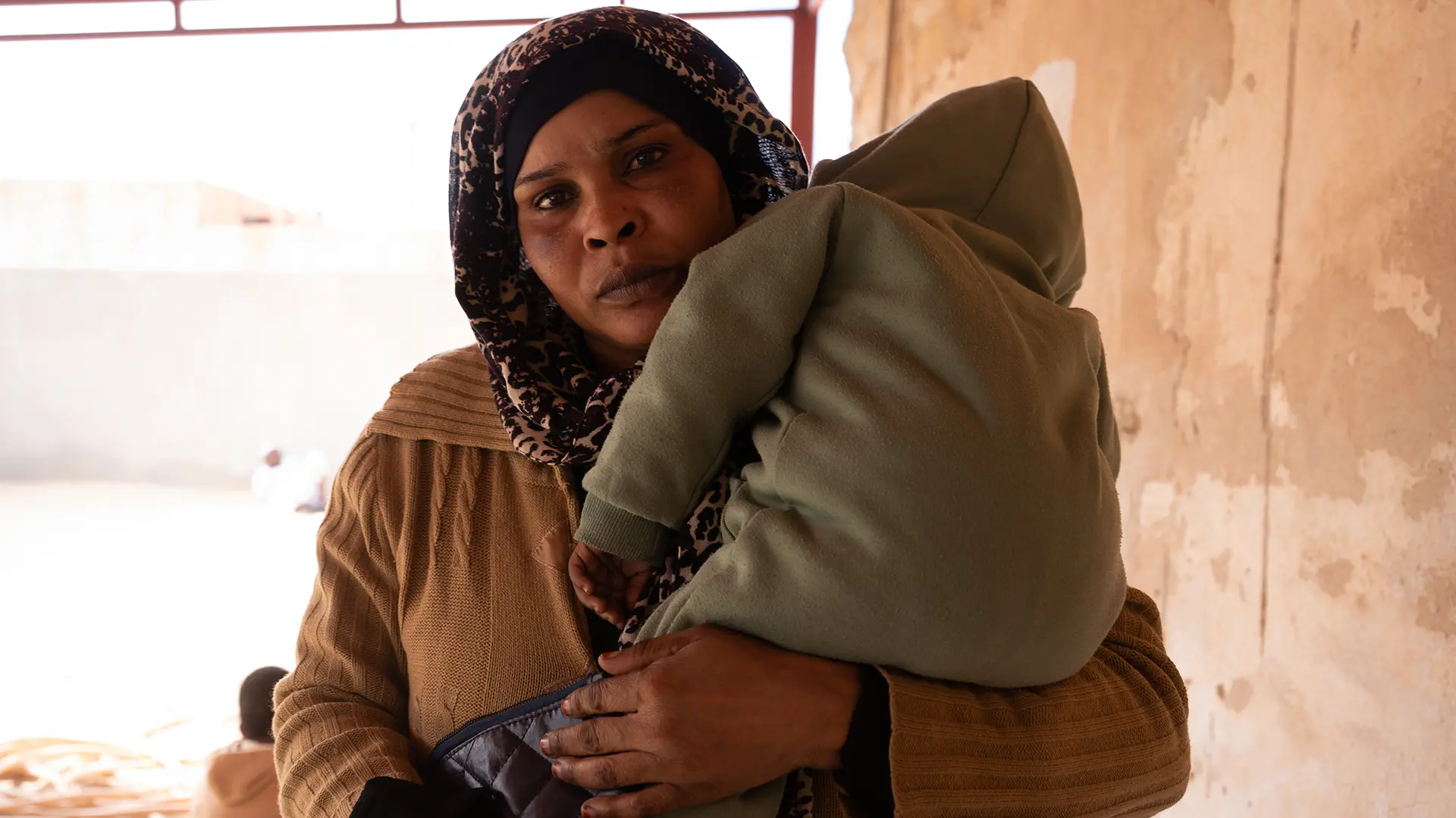 Una mujer está de pie en la sala de espera de uno de los centros de salud donde MSF brinda atención en la ciudad de Zuwara, Libia.
