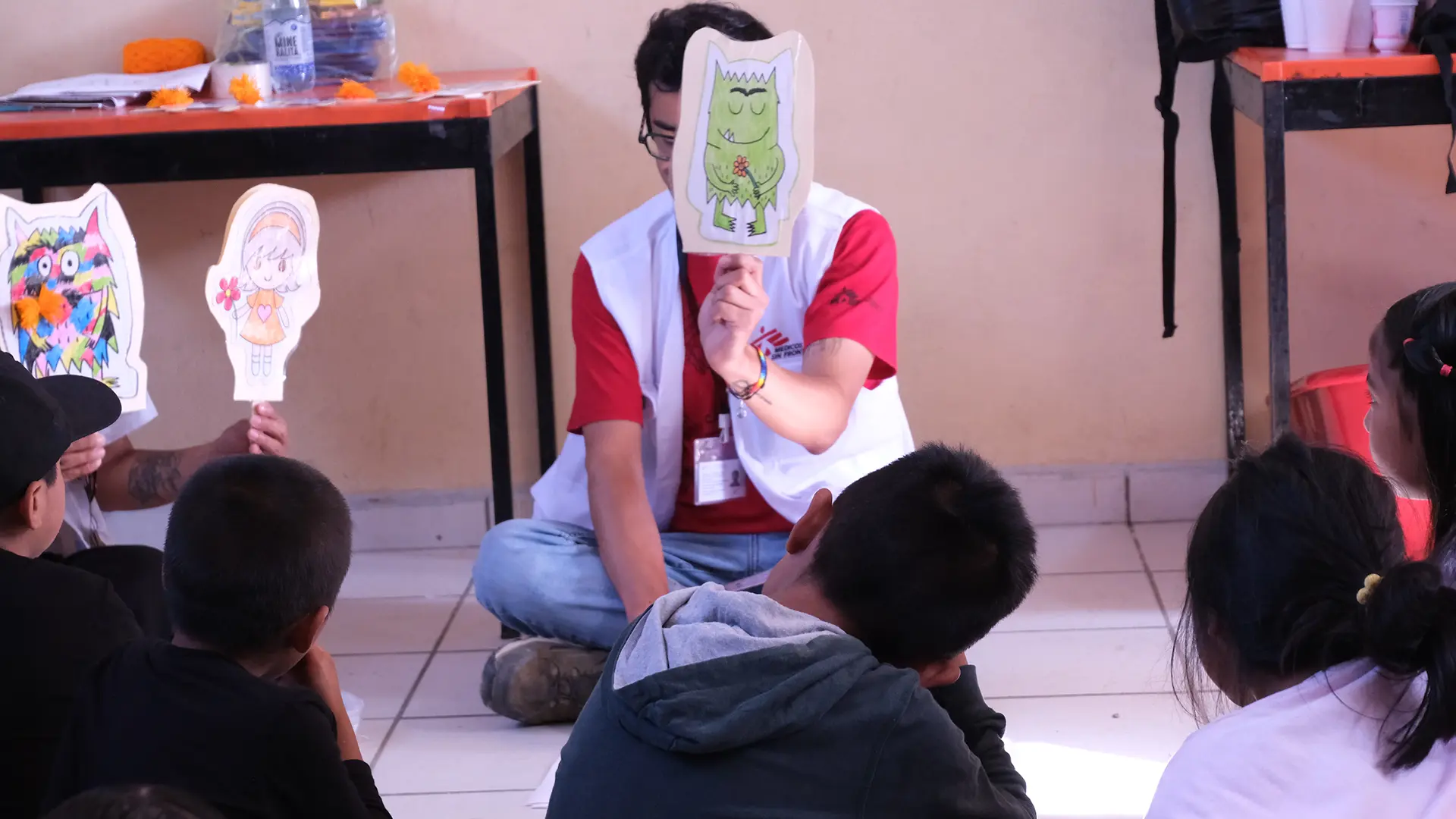 Niños observan la obra "El monstruo de colores" donde aprenden de gestión de emociones y salud mental. 