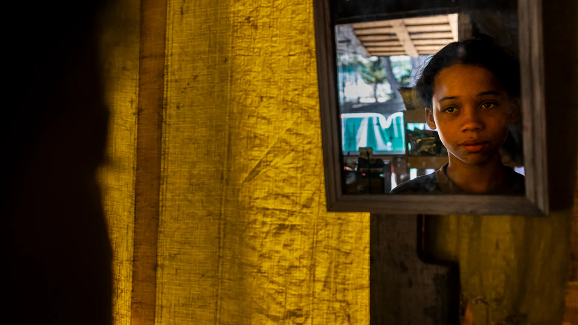 Lucila posa para un retrato dentro de la tienda de dulces, cigarrillos y refrescos de su madre, cuyas ventas han ayudado a cubrir los gastos familiares después de meses de incertidumbre causada por la interrupción de su viaje hacia Estados Unidos.