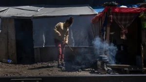 Carmen limpia el exterior de su “ranchito” en el barrio de Vallejo, el lugar que ha sido su hogar durante los últimos meses luego de que ya no pudiera continuar su viaje a Estados Unidos en busca de una vida con más oportunidades y seguridad para ella y su familia.