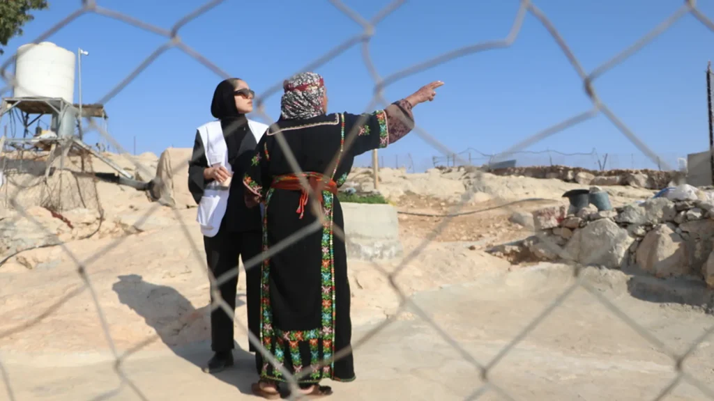 Un trabajador social de MSF conversa con Sabha Al Najar, quien, junto con su esposo, Mahomud, fue atacado y golpeado por colonos a principios de noviembre de 2025 en su hogar en Shi'b al-Butum, al sur de Hebrón. Cisjordania, Palestina.