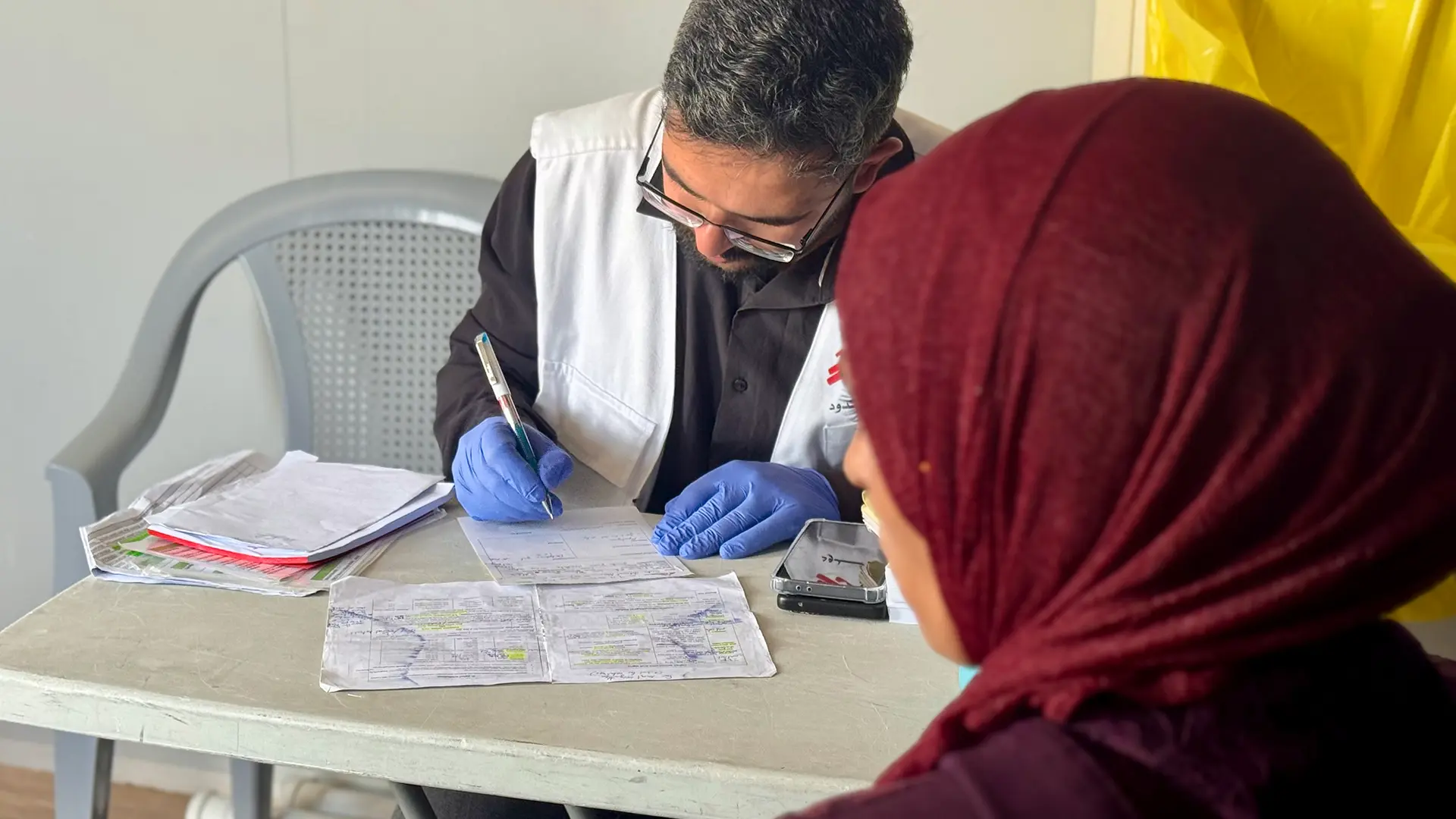 Un médico de MSF escribe una receta después de examinar a un paciente en la clínica Al Majaz, Masafer Yatta, Cisjordania, Palestina.