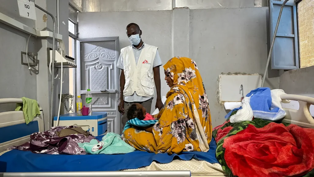 Ferdos Salih sostiene a su bebé de 11 meses, Banan, quien padece sarampión, en la sala de aislamiento del Hospital Universitario El Geneina, con apoyo de MSF. Sudán, diciembre de 2025.