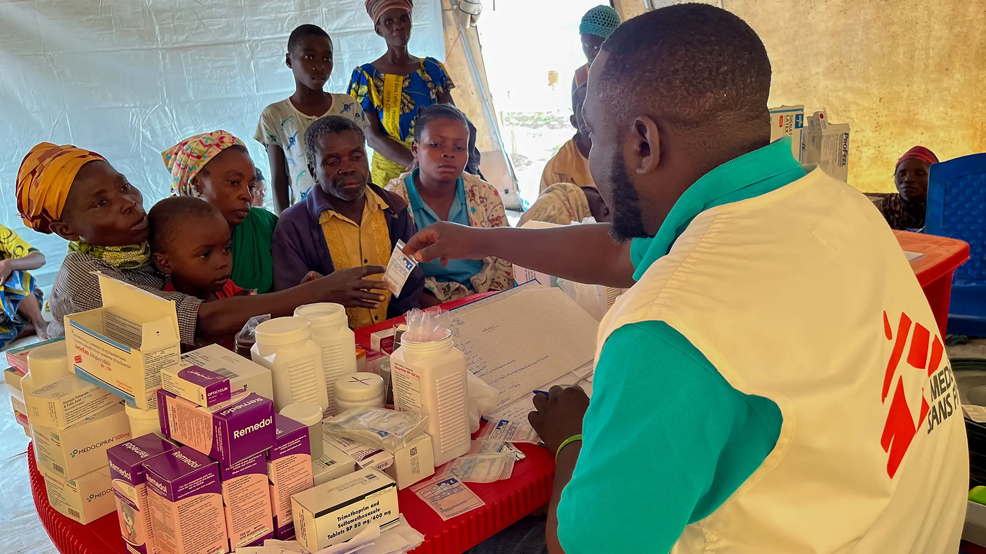 Personas refugiadas congoleñas que viven en el campo de Ndava reciben medicamentos en la clínica móvil de MSF.