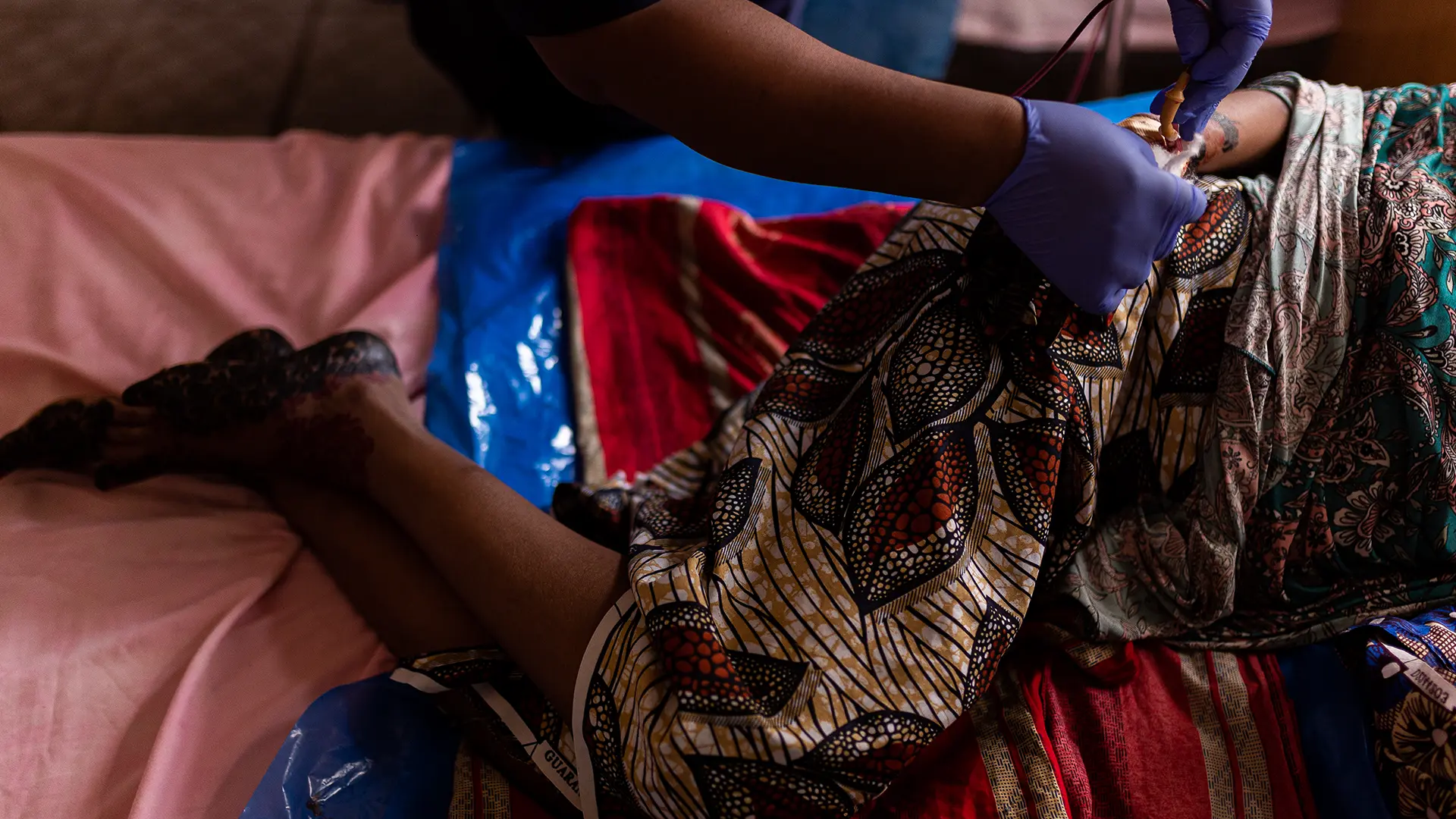 Amina Tahila (27), una madre primeriza, se acuesta en la cama con su bebé y un kit gratuito de elementos esenciales para el cuidado posparto (llamado paquete Mamá) proporcionado por MSF para las nuevas madres que dan a luz en el Hospital General Shinkafi.