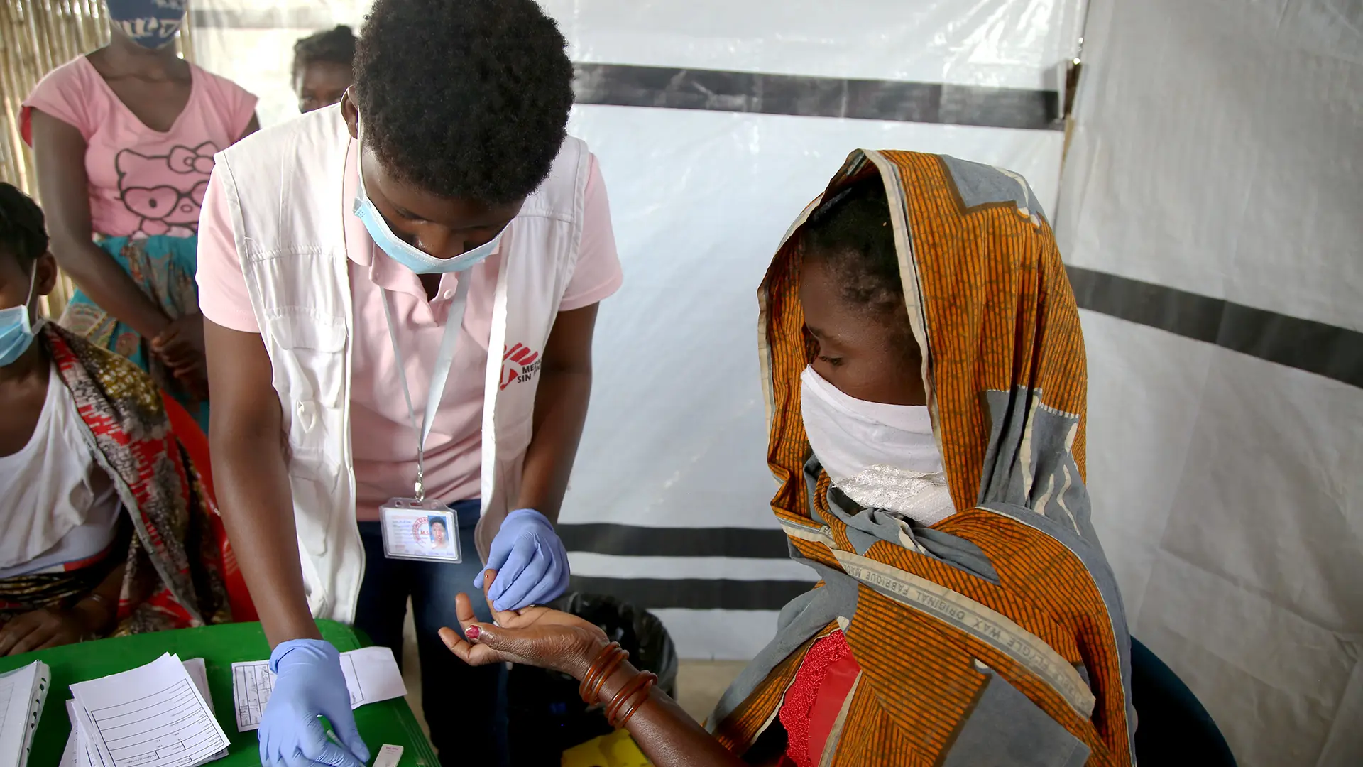 Una enfermera realiza una prueba de malaria a una mujer en un puesto de salud de MSF, Mueda,  Cabo Delgado.