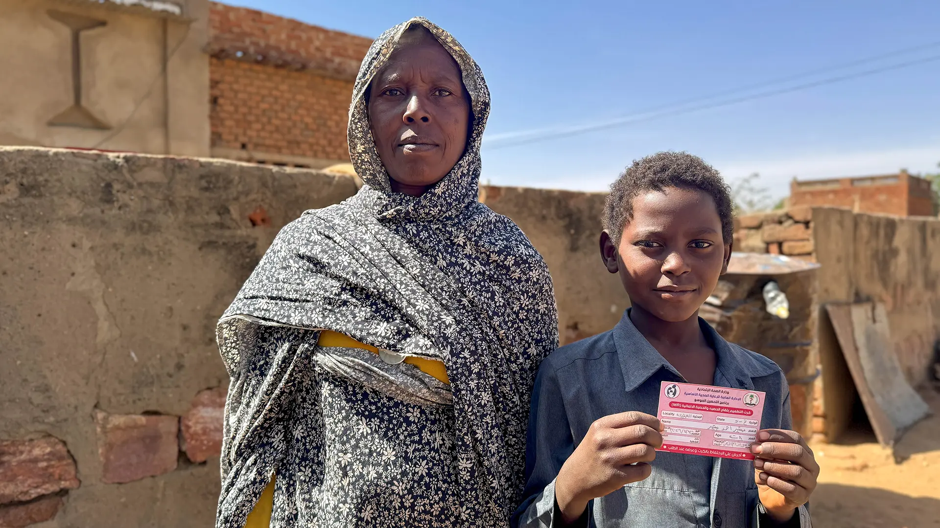 Hamaza, de 11 años, y su madre, Mariam, asisten a la campaña de vacunación en Umalgora, Darfur Occidental. 