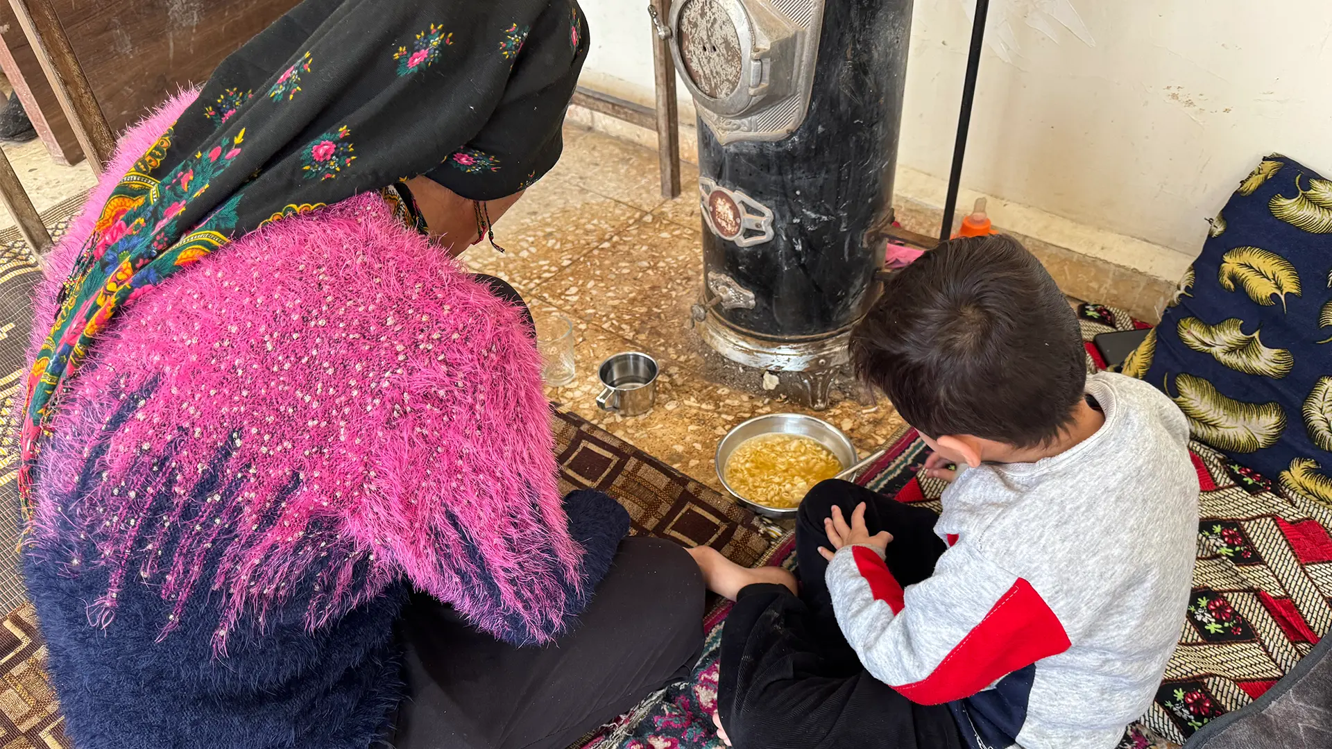 Layla Tobal, mujer de 42 años de Afrin, y su hijo de 5 años comiendo sopa en uno de los centros colectivos de Qamishli.