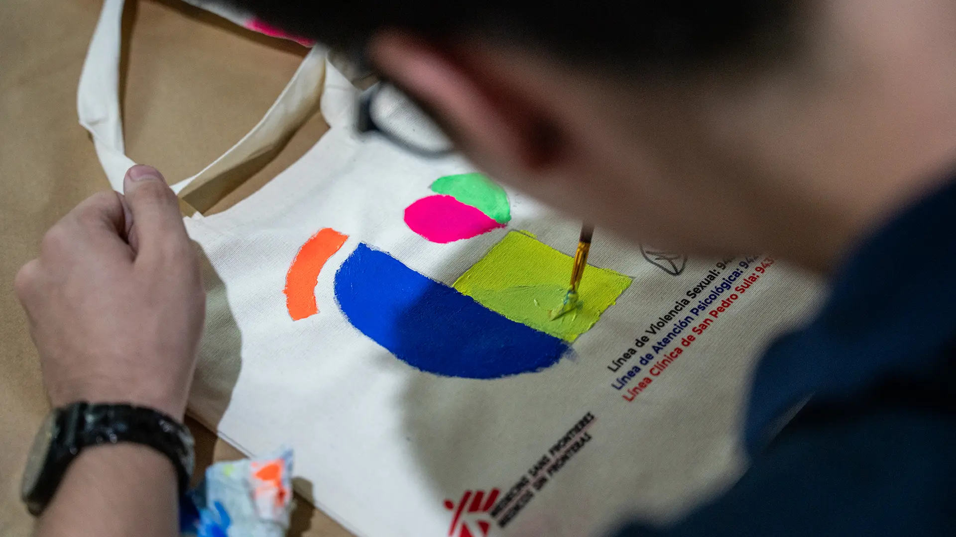 paciente de MSF, pinta una bolsa de tela como parte de las celebraciones que conmemoran los cuatro años de trabajo de MSF en la clínica de San Pedro Sula.