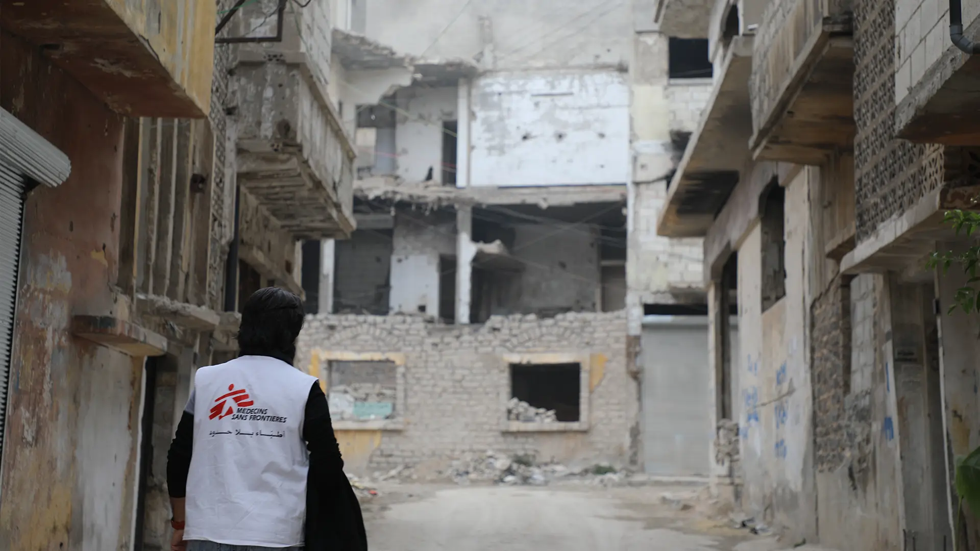 Una enfermera de MSF camina, reflexionando sobre la extensa destrucción en el barrio de Al-Khalediya, en la ciudad de Homs. La destrucción es testimonio de una guerra sangrienta que duró catorce años.