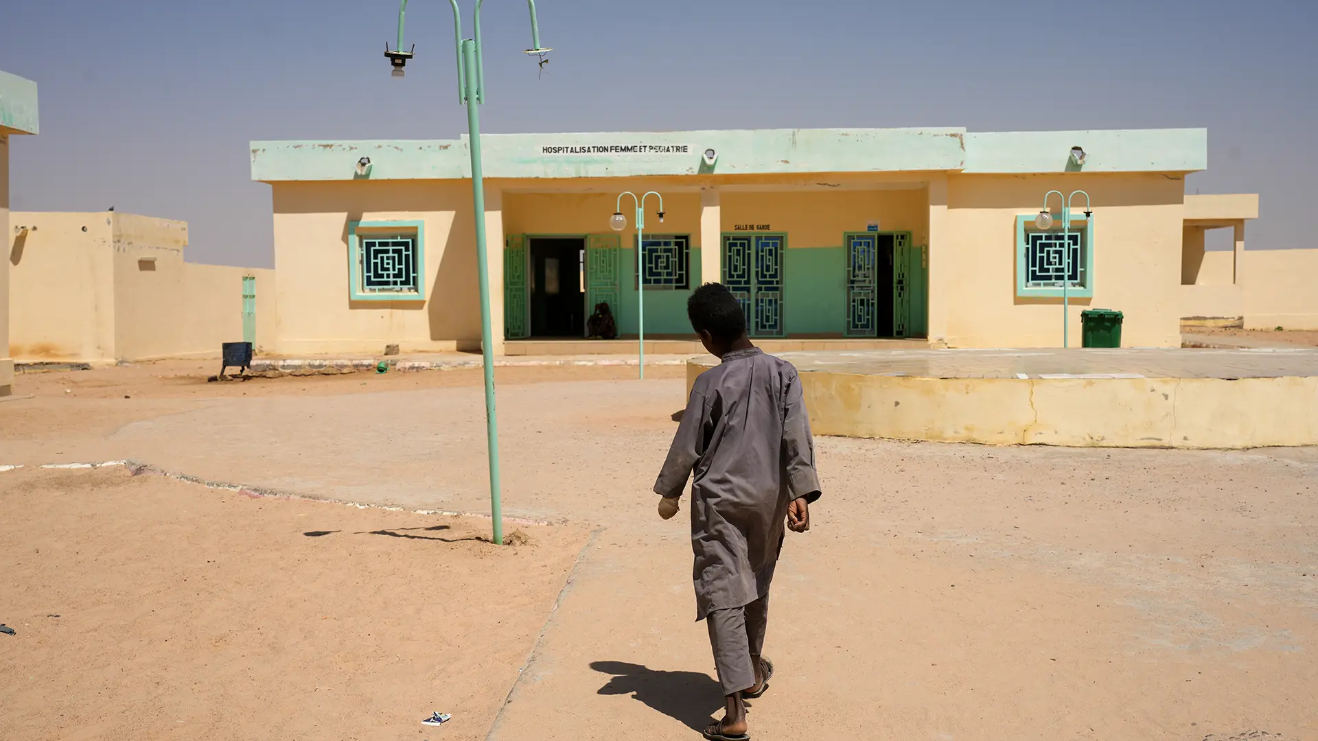 Un niño camina frente a un centro de salud en Tine, Chad, junio de 2025.