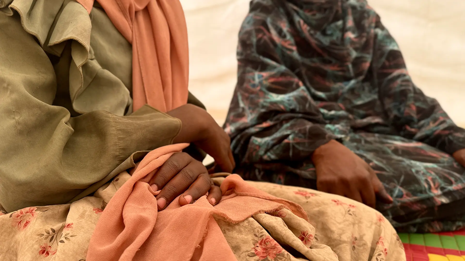 Amna*, de 13 años, huyó de El Fasher después de que un proyectil impactara en su casa, matando a sus padres y dos hermanos. Ahora vive con su hermana de 15 años en un campo para desplazados en Sudán; ambos menores no acompañados.