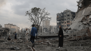 Guerra en Gaza: Personas se encuentran en medio de un edificio destruido después de un ataque aéreo en Gaza.