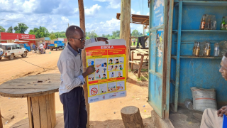 Un promotor de salud de MSF habla con un comerciante en Madudu, cerca del epicentro del brote de Ébola en Uganda.