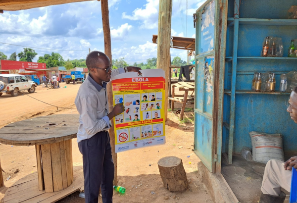 Un promotor de salud de MSF habla con un comerciante en Madudu, cerca del epicentro del brote de Ébola en Uganda.