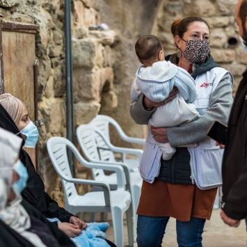 Una integrante de MSF cargando a un bebé en Hebron