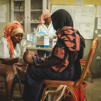 El personal del Ministerio de Salud en el hospital, durante una examinación a un niño por desnutrición en el centro de alimentación terapéutica para pacientes hospitalizados en el Hospital de Dupti. © Njiiri Karago/MSF
