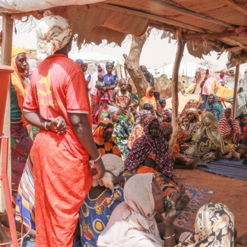 En un campo para personas internamente desplazadas en la ciudad de Gorom Gorom, en la región saheliana de Burkina Faso, un grupo de mujeres se reunen con los equipos de promoción de la salud de MSF para hablar de acceso a la atención médica. © Mohamed El-Habib Cisse/MSF