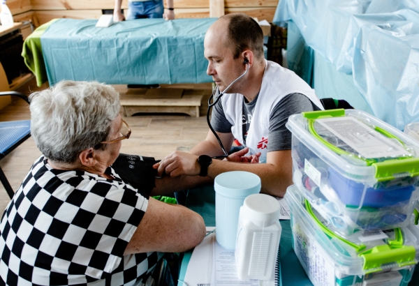 Igor Bodnia, médico ucraniano de MSF, escuchando a su paciente durante una de las clínicas móviles de MSF. La clínica se instaló en un restaurante qu se convirtió en un centro de ayuda humanitaria en Járkiv. © Pavel Dorogoy