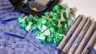 Una colección de plumas de insulina y tapones de agujas junto a un glucómetro en la clínica de MSF en Arsal, al norte del Líbano, donde MSF reintrodujo las plumas de insulina como parte de su atención médica gratuita para personas con diabetes tipo 1.