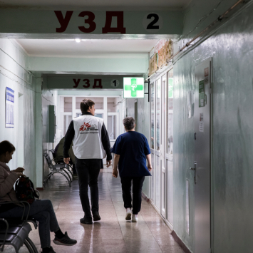 Anna Svesova, directora del hospital en Trostianets, Ucrania, caminando junto a un integrante de MSF (hombre) por un pasillo del recinto.