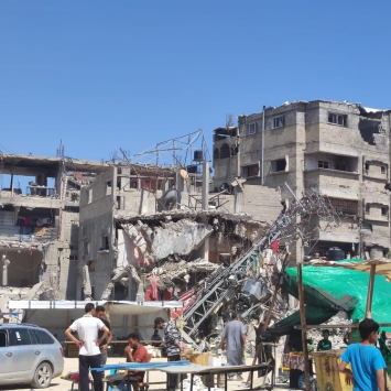 Un grupo de personas frente a un edificio bombardeado en Rafah, Gaza.
