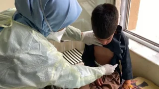 Una enfermera de MSF examina a Sebgatullah, de nueve años, diagnosticado de sarampión, en la sala de aislamiento del Hospital Regional de Herat.